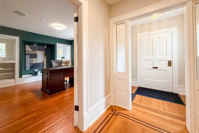 Library and home office with green walls and built-in shelving, off the front hall. - North Vancouver