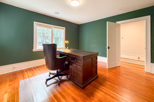 Library and home office with green walls, a double window and hardwood floors. - North Vancouver