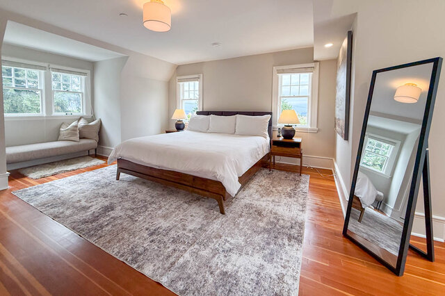 Primary bedroom with dormer windows, a window bench nook, hardwood floors and a mountain view. - North Vancouver
