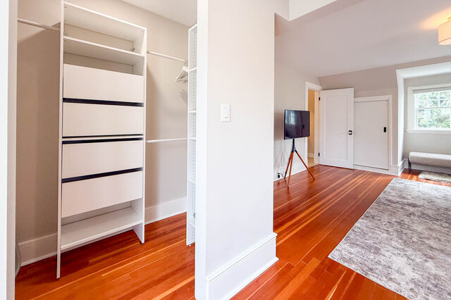 Second closet off the primary bedroom with built-in drawers and hanging rods. - North Vancouver