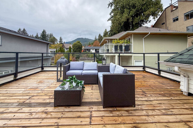 Private upper deck off the primary bedroom with a glass railing, cedar decking and a mountain view. - North Vancouver