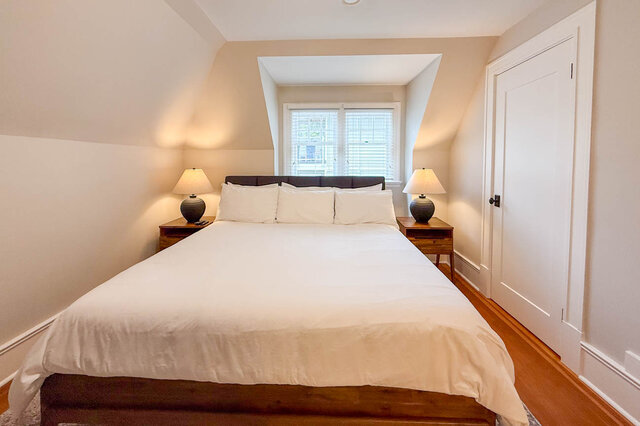 Second bedroom under sloped ceilings with a dormer window and a closet. - North Vancouver