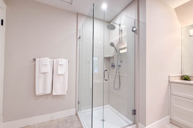 Glass walk-in shower with a rain shower head in the main bathroom. - North Vancouver