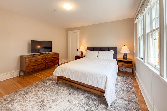 Third bedroom with tall windows, a closet and hardwood floors. - North Vancouver