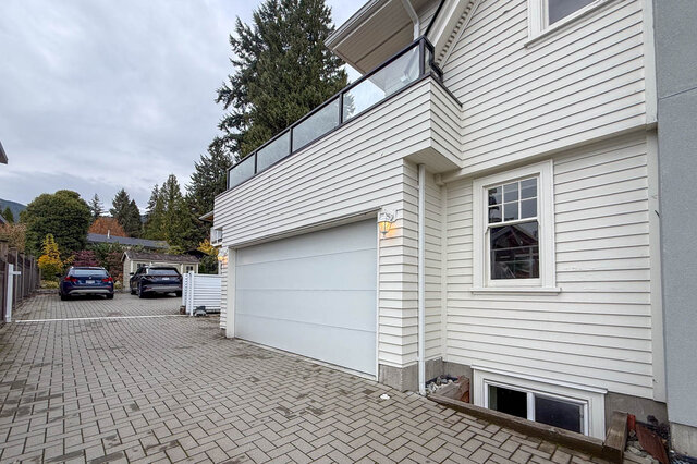 Garage under the private upper deck, with a paver driveway. - North Vancouver